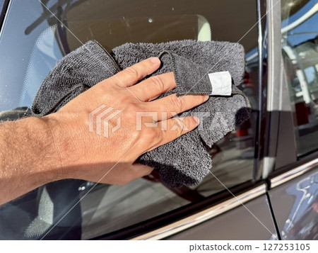 Man hand cleaning car with microfiber cloth at car wash Man hand cleaning car with microfiber cloth at car wash 127253105