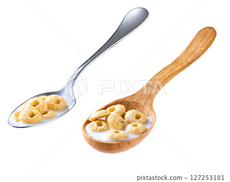 Whole grain cereal rings with milk in a metal spoon isolated on white background. Whole grain cereal rings with milk in a metal spoon isolated on white background. 127253181