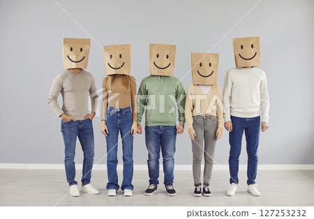 Portrait of group of people wearing paper bags with smiling emoticons drawn on their heads. 127253232