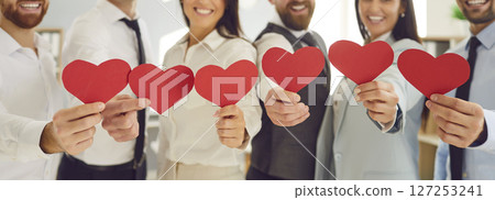 Group of smiling business people holding red hearts, close-up Group of smiling business people holding red hearts, close-up 127253241