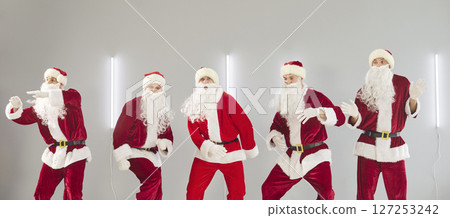 People in Santa Claus suits dancing together enjoying Christmas or New Year party. People in Santa Claus suits dancing together enjoying Christmas or New Year party. 127253242