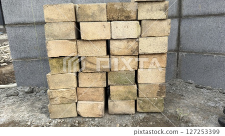 Building a flower bed in the garden, exterior construction with bricks and cement Building a flower bed in the garden, exterior construction with bricks and cement 127253399