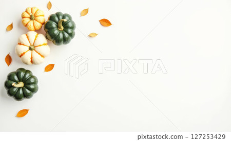 Autumn pumpkins and fall leaves on white background. Minimalist harvest and Halloween season flat lay composition. 127253429