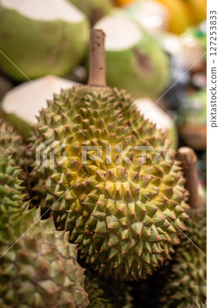 Durian fruits on supermarket shelf ready for customer selection, close up. Grocery stalls in Asia Durian fruits on supermarket shelf ready for customer selection, close up. Grocery stalls in Asia 127253833