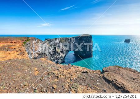 Impressive andscape with unique basalt arch on Dyrholaey Nature Reserve on Atlantic South Coast. Impressive andscape with unique basalt arch on Dyrholaey Nature Reserve on Atlantic South Coast. 127254201
