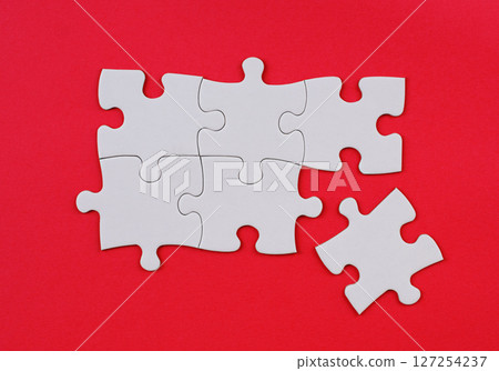 White Puzzle Pieces on Red Background. Missing Piece Concept. Stock photo. White Puzzle Pieces on Red Background. Missing Piece Concept. Stock photo. 127254237