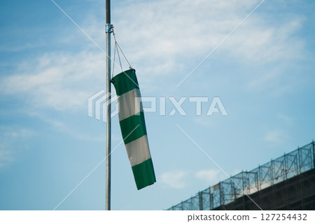 Green and white safety flag and blue sky Green and white safety flag and blue sky 127254432