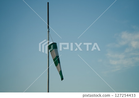 Green and white safety flag and blue sky Green and white safety flag and blue sky 127254433