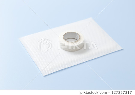 Compress and surgical tape on a blue background Compress and surgical tape on a blue background 127257317