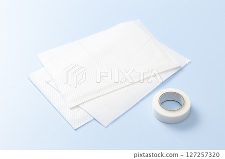 Compress and surgical tape on a blue background Compress and surgical tape on a blue background 127257320