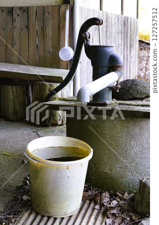 Hand pump and water in a bucket Hand pump and water in a bucket 127257512