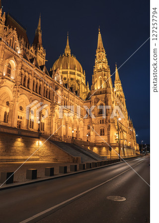 The Hungarian Parliament Building in Budapest glows at night, showcasing its neo Gothic architecture, spires, and dome under a clear night sky. 127257794