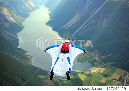 Wingsuit Flying Over a Stunning Fjord Landscape During a Clear Day in Norway 127260429