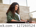 Pretty curly women works at laptop sitting, work online, shopping online, communication in social networks, online learning, freelancer 127260524