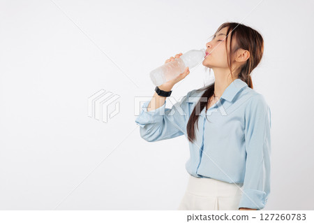 Young asian woman holds plastic water bottle, eyes closed, enjoys a refreshing drink because she wants to drink some water and stay hydrated, isolated studio white background Young asian woman holds plastic water bottle, eyes closed, enjoys a refreshing drink because she wants to drink some water and stay hydrated, isolated studio white background 127260783
