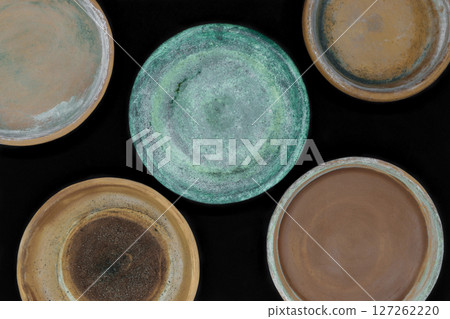 Background surface of various colors and dirty clay plates for plants and isolated on black background Background surface of various colors and dirty clay plates for plants and isolated on black background 127262220