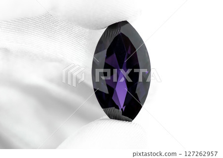 Hand with white gloves holding purple amethyst gemstone 127262957