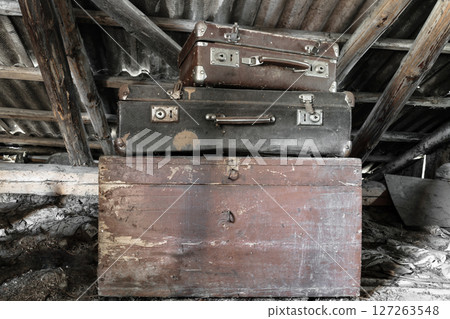 Two Old, Rusty, Dusty and Dirty Suitcases Lying on the Brown Chest in Attic Two Old, Rusty, Dusty and Dirty Suitcases Lying on the Brown Chest in Attic 127263548