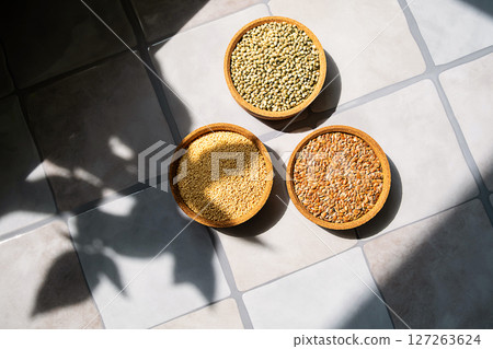 Three Bowls with Amaranth, Flax and Hemp Seeds on a Tile Surface with Sunlight. Healthy and Nutritious Food. Three Bowls with Amaranth, Flax and Hemp Seeds on a Tile Surface with Sunlight. Healthy and Nutritious Food. 127263624
