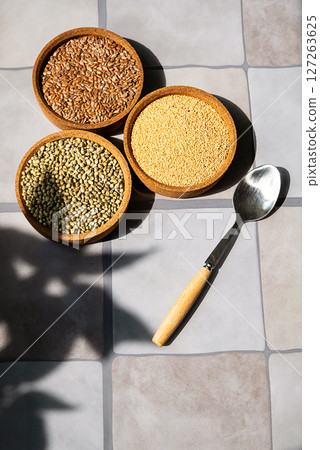 Bowls Containing Amaranth, Linen and Hemp seeds with a Spoon on Tiled Surface. Healthy Eating and Superfood Concept. Bowls Containing Amaranth, Linen and Hemp seeds with a Spoon on Tiled Surface. Healthy Eating and Superfood Concept. 127263625