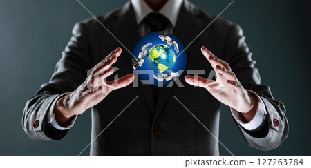 businessman holding a sphere with a globe in his hands. 127263784
