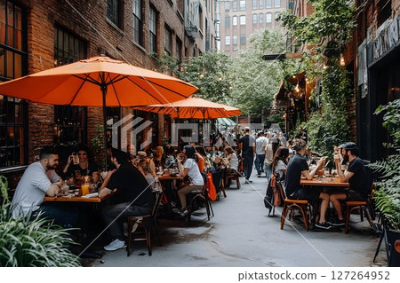 Vibrant outdoor dining scene with people enjoying meals on a bustling patio 127264952