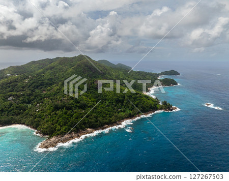 The coastline of the island and clear turquoise water with a tropical forest. Seychelles, Mahe. The coastline of the island and clear turquoise water with a tropical forest. Seychelles, Mahe. 127267503