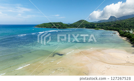 Golden sandy beach, gentle waves, and tropical vegetation. Seychelles, Mahe. 127267528