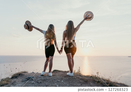 Two Women Admiring Sunset on a Cliff 127268323