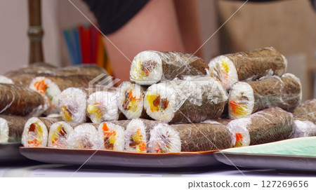 Wrapped futomaki sushi rolls on serving trays Wrapped futomaki sushi rolls on serving trays 127269656