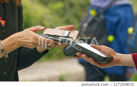 Close-Up of Contactless Mobile Payment Using Smartphone Near POS Terminal Outdoors Close-Up of Contactless Mobile Payment Using Smartphone Near POS Terminal Outdoors 127269658