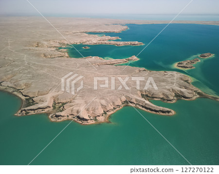 Aerial view of Kuimazar Reservoir and rugged desert shoreline in Uzbekistan 127270122