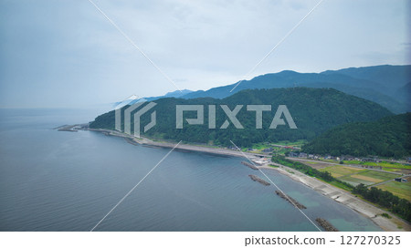 A view of the Sasagawa district and offshore wind turbines along the coast of Nyuzen town and the mouth of a stream, seen from the coast of Asahi town, Toyama prefecture, during the rainy season A view of the Sasagawa district and offshore wind turbines along the coast of Nyuzen town and the mouth of a stream, seen from the coast of Asahi town, Toyama prefecture, during the rainy season 127270325
