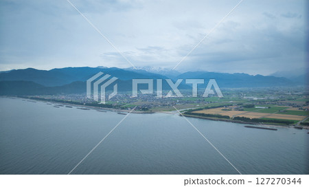 A view of the Sasagawa district and offshore wind turbines along the coast of Nyuzen town and the mouth of a stream, seen from the coast of Asahi town, Toyama prefecture, during the rainy season 127270344