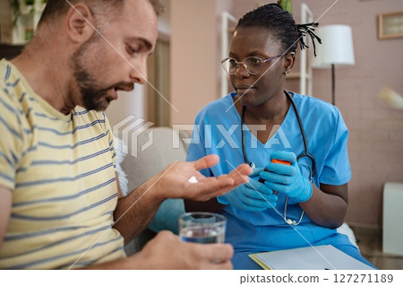 Caring nurse guides patient with medicine management Caring nurse guides patient with medicine management 127271189