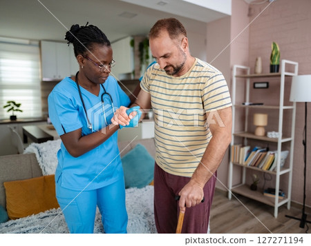 Nurse assisting patient in home care setting Nurse assisting patient in home care setting 127271194