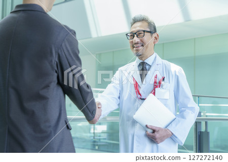 A doctor and a man in a suit shaking hands at a hospital. Photo courtesy of Sky Perfect Tokyo Media Center. 127272140
