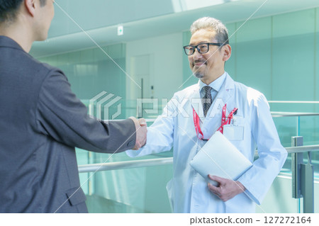 醫院裡，一位醫生和一位穿著西裝的男子握手。照片由Sky Perfect Tokyo Media Center提供。 127272164