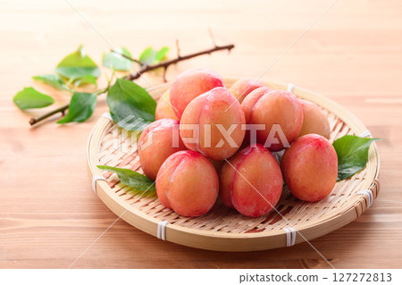 淺色木紋背景上酸甜可口的李子（早期） 127272813