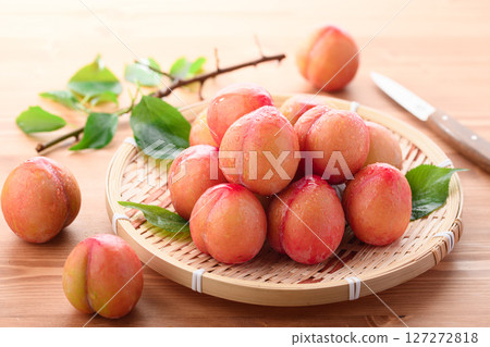 Sweet and sour, delicious plums (early) on a light wood grain background 127272818