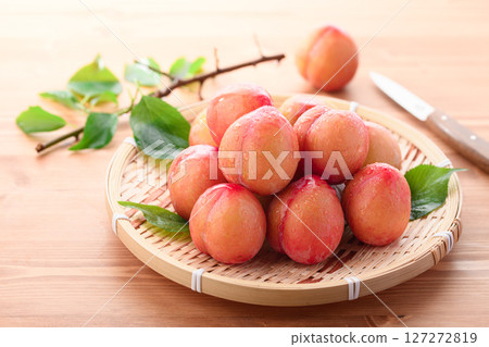 Sweet and sour, delicious plums (early) on a light wood grain background 127272819