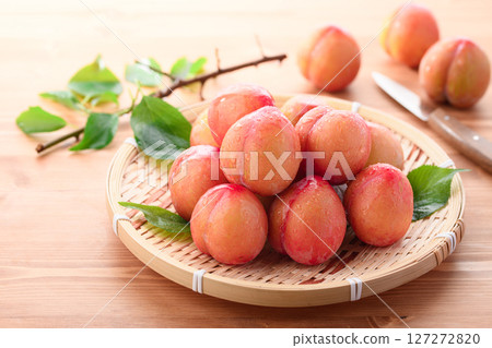 Sweet and sour, delicious plums (early) on a light wood grain background 127272820