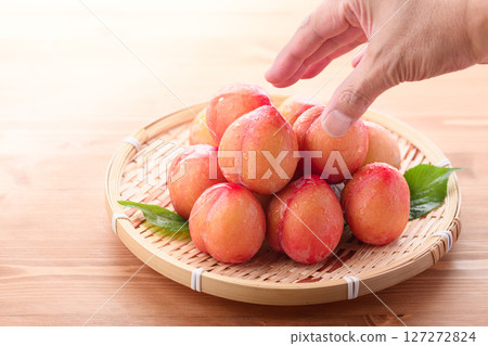 Sweet and sour, delicious plums (early) on a light wood grain background 127272824