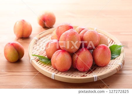Sweet and sour, delicious plums (early) on a light wood grain background 127272825