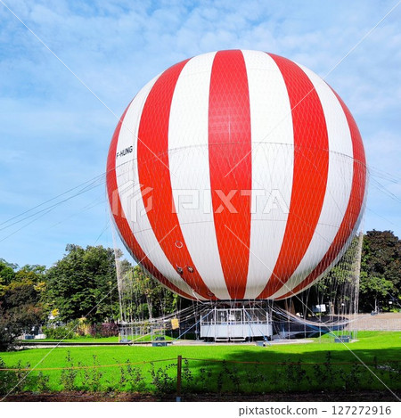 Hot Air Balloon sitting at the green lawn with blue sky white clouds background, travel adventure tour. Romance of ballooning in a good weather Hot Air Balloon sitting at the green lawn with blue sky white clouds background, travel adventure tour. Romance of ballooning in a good weather 127272916