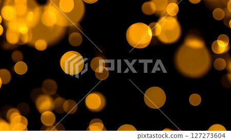 A captivating display of golden bokeh lights dancing on a pitch black canvas 127273604