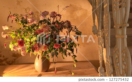 A bouquet of wildflowers in a vase. Wildflowers in an old house under an old spiral staircase. A bouquet of wildflowers and sunflowers. A concept of old times and romance 127275432