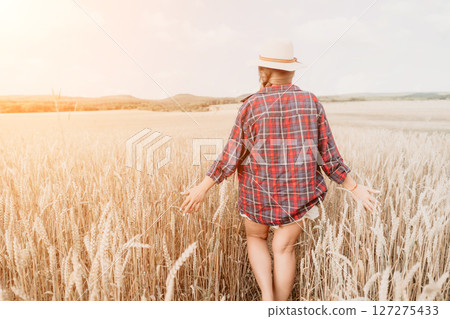 Woman wheat field. Agronomist, Woman farmer check golden ripe barley spikes in cultivated field. Closeup of female hand on plantation in agricultural crop management concept. Slow motion Woman wheat field. Agronomist, Woman farmer check golden ripe barley spikes in cultivated field. Closeup of female hand on plantation in agricultural crop management concept. Slow motion 127275433