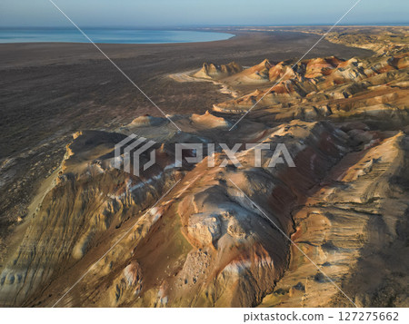 Curved ridges, stratified slopes of Aktumsuk cape overlooking Aral Sea remnant Curved ridges, stratified slopes of Aktumsuk cape overlooking Aral Sea remnant 127275662