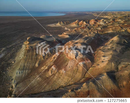 Eroded sandstone hills of Aktumsuk cape forming intricate patterns at sunset 127275665